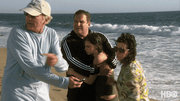 GIF of a woman throwing Larry David&#x27;s phone in the ocean in &quot;Curb Your Enthusiasm&quot;