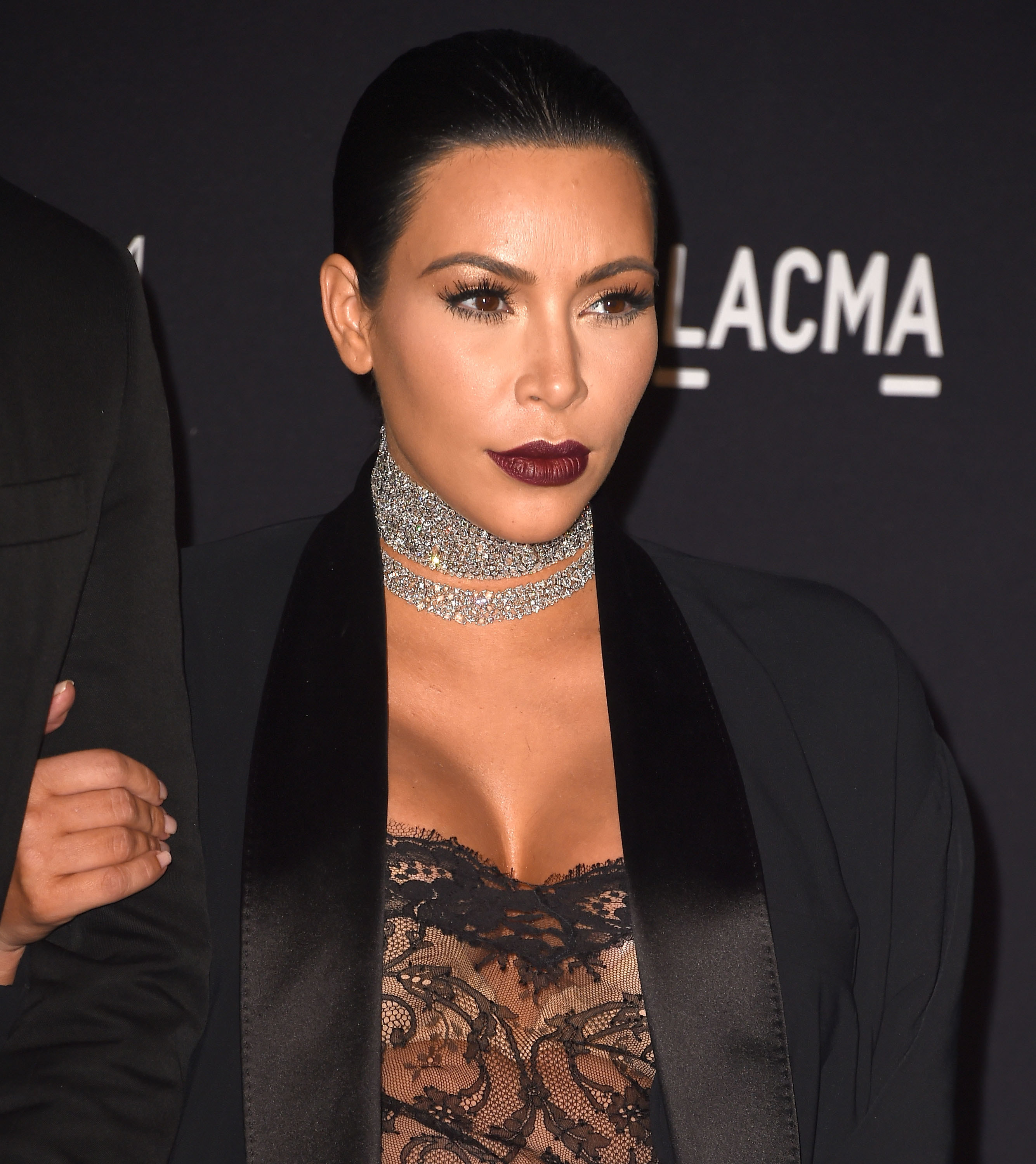 Close-up of Kim wearing a thick bejeweled choker necklace