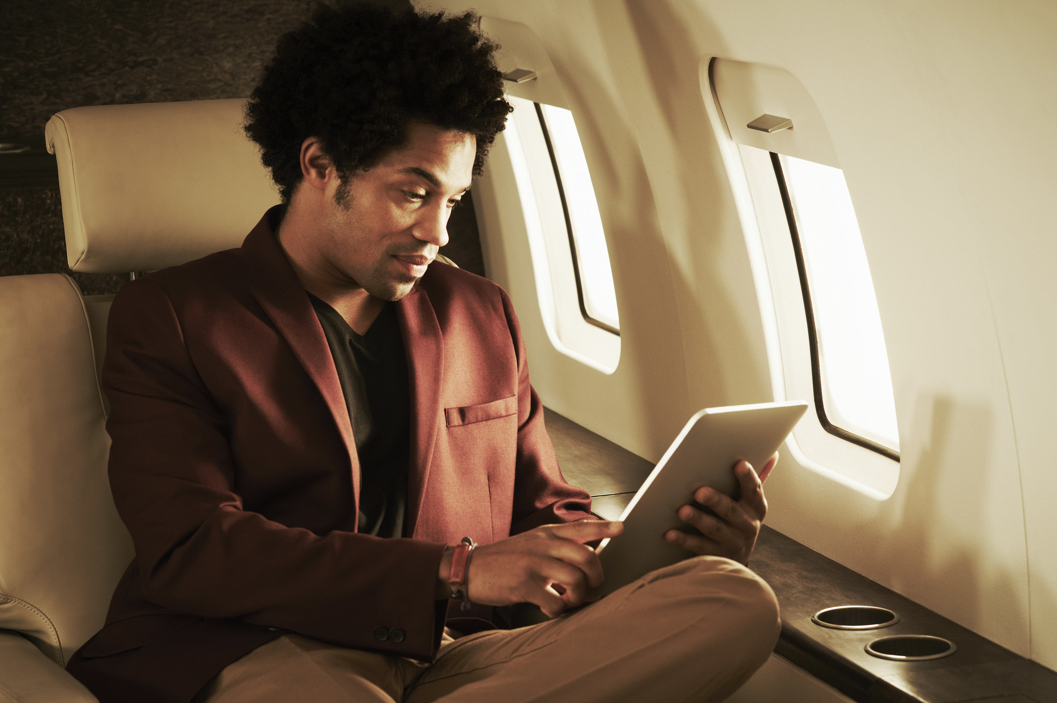 A man using a tablet on a private plane
