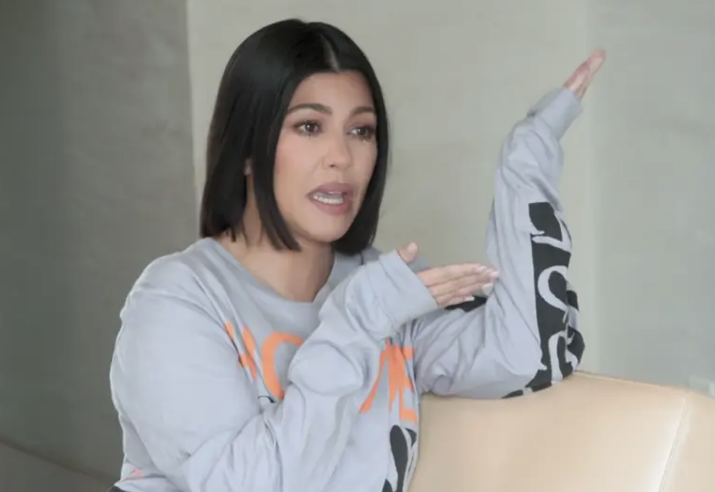 Kourtney sitting on a couch and gesturing