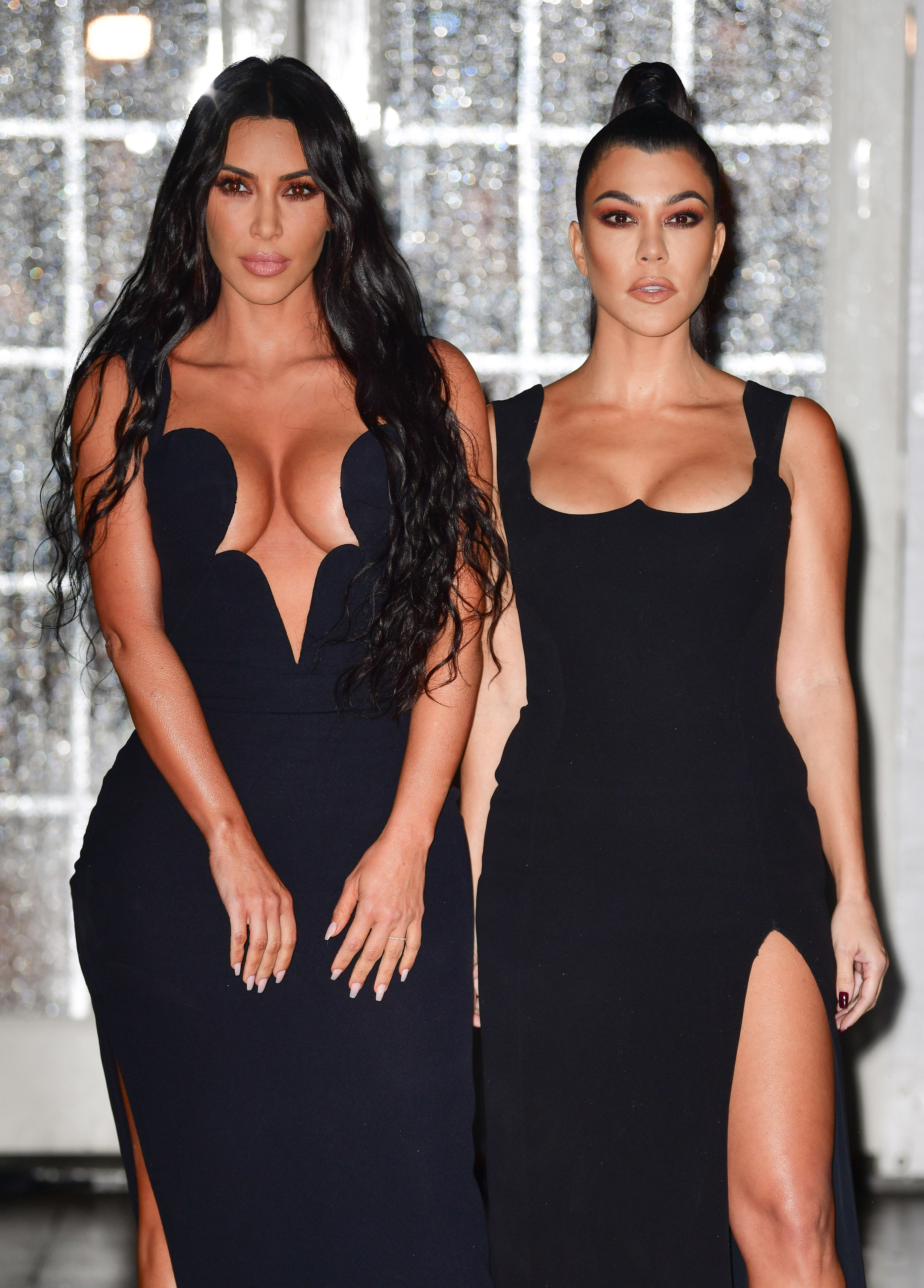 Kim and Kourtney standing together and looking serious