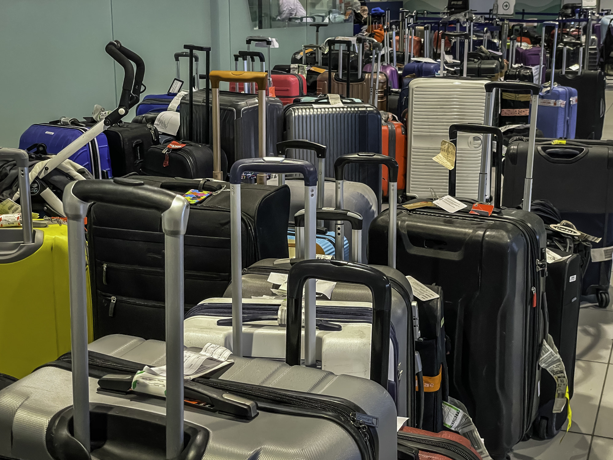 A large assortment of luggage with tags on them