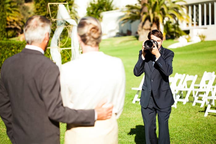 A photographer taking a photo of a couple at a wedding