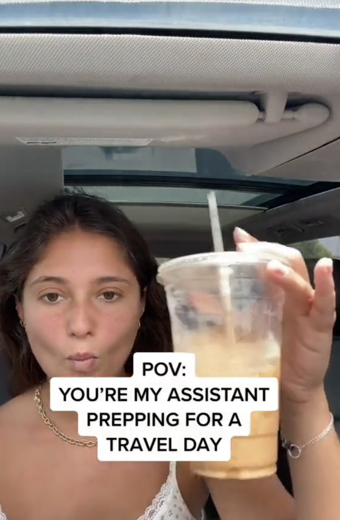 Alexa holding up a large iced coffee with caption, &quot;POV: you&#x27;re my assistant prepping for a travel day&quot;