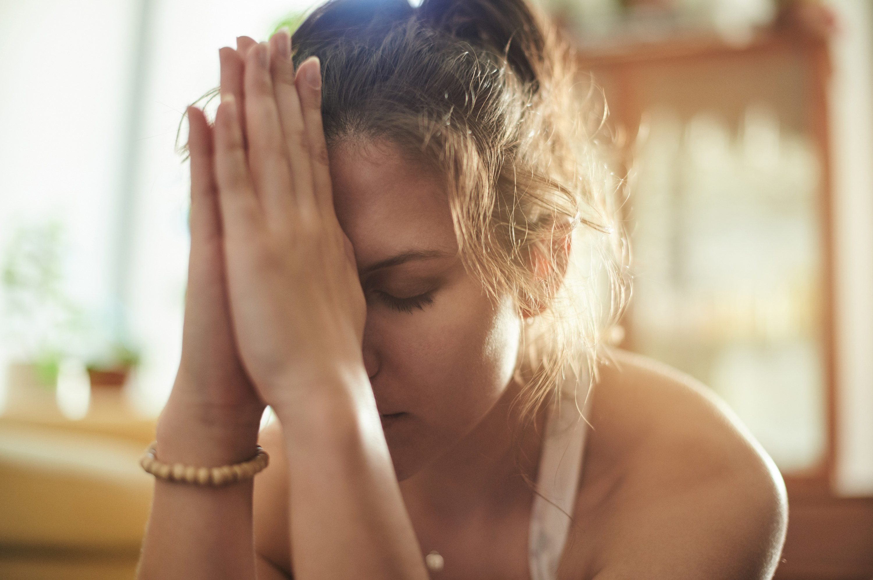 A woman with her eyes closed praying