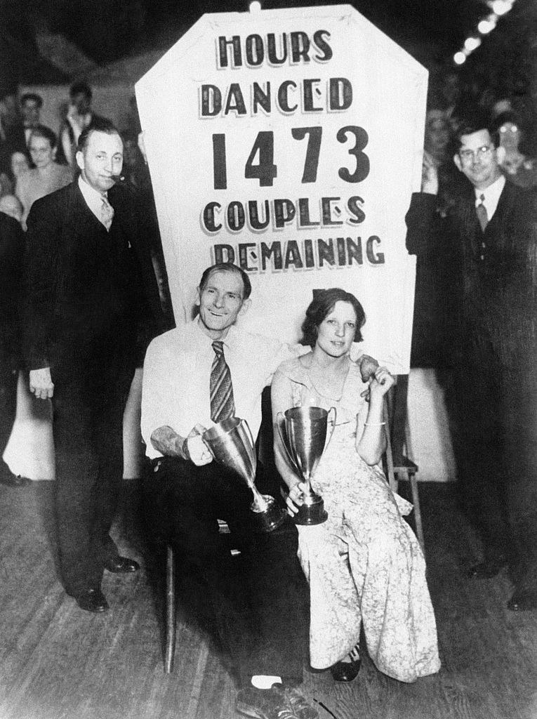 old photo of a couple holding trophies for dancing in the marathon