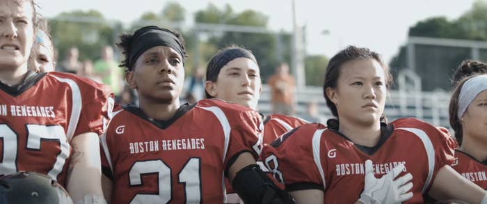 women football players stand in uniform for the national anthem