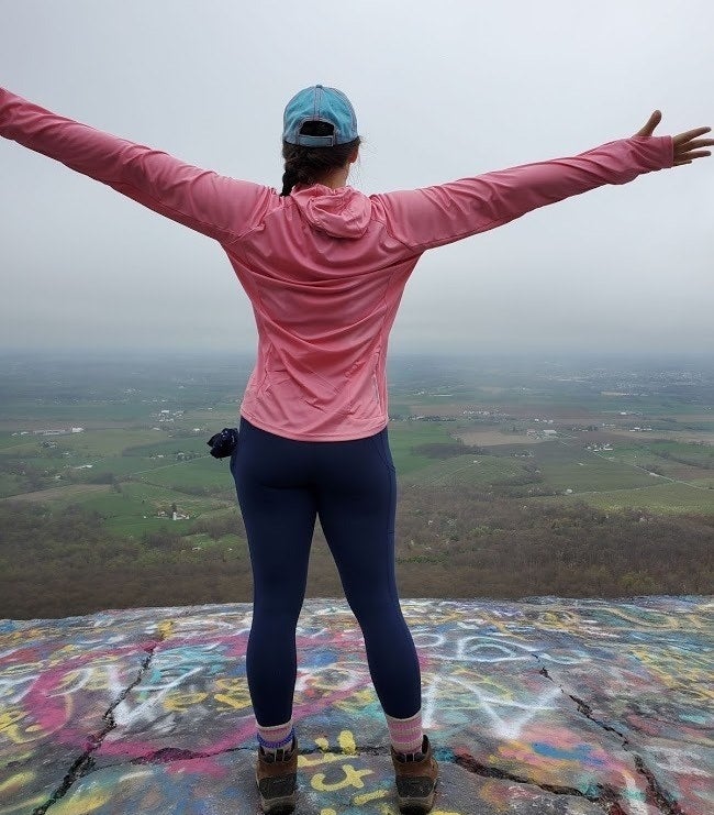 a reviewer on a hike wearing the blue leggings