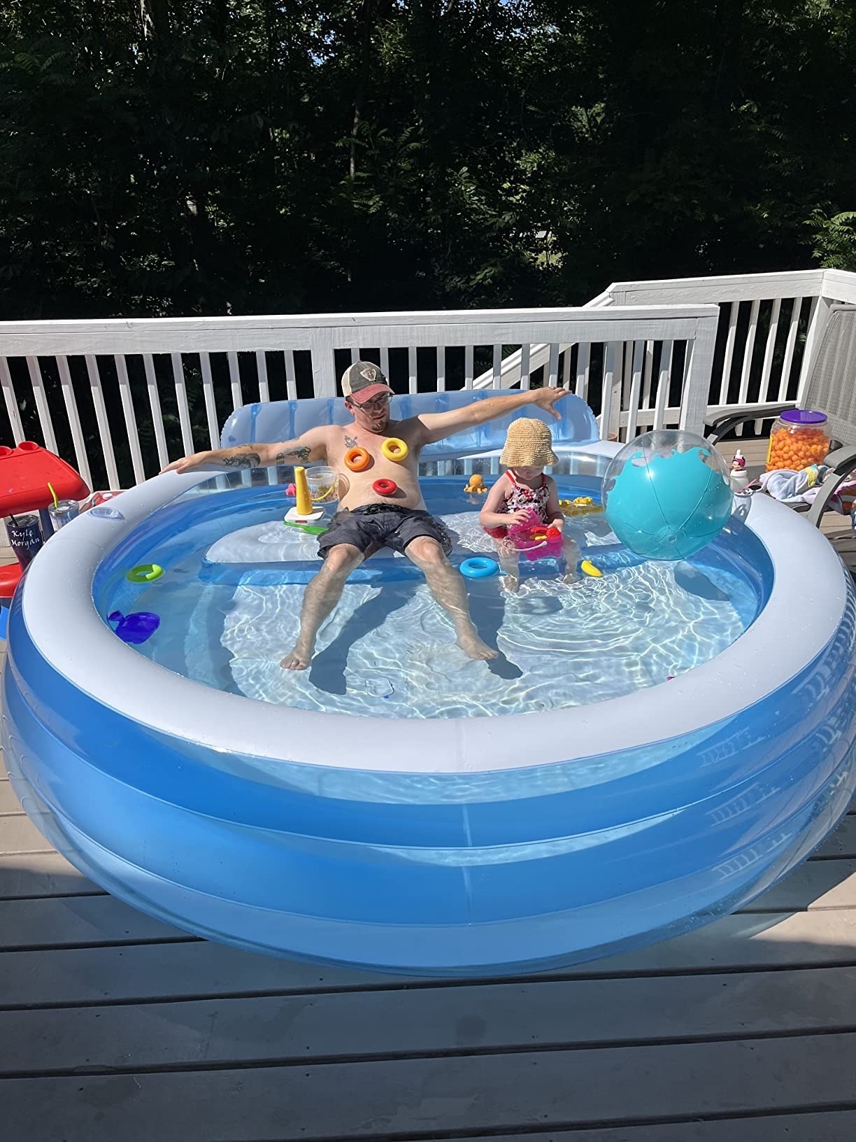 a reviewer sitting in the pool with their child