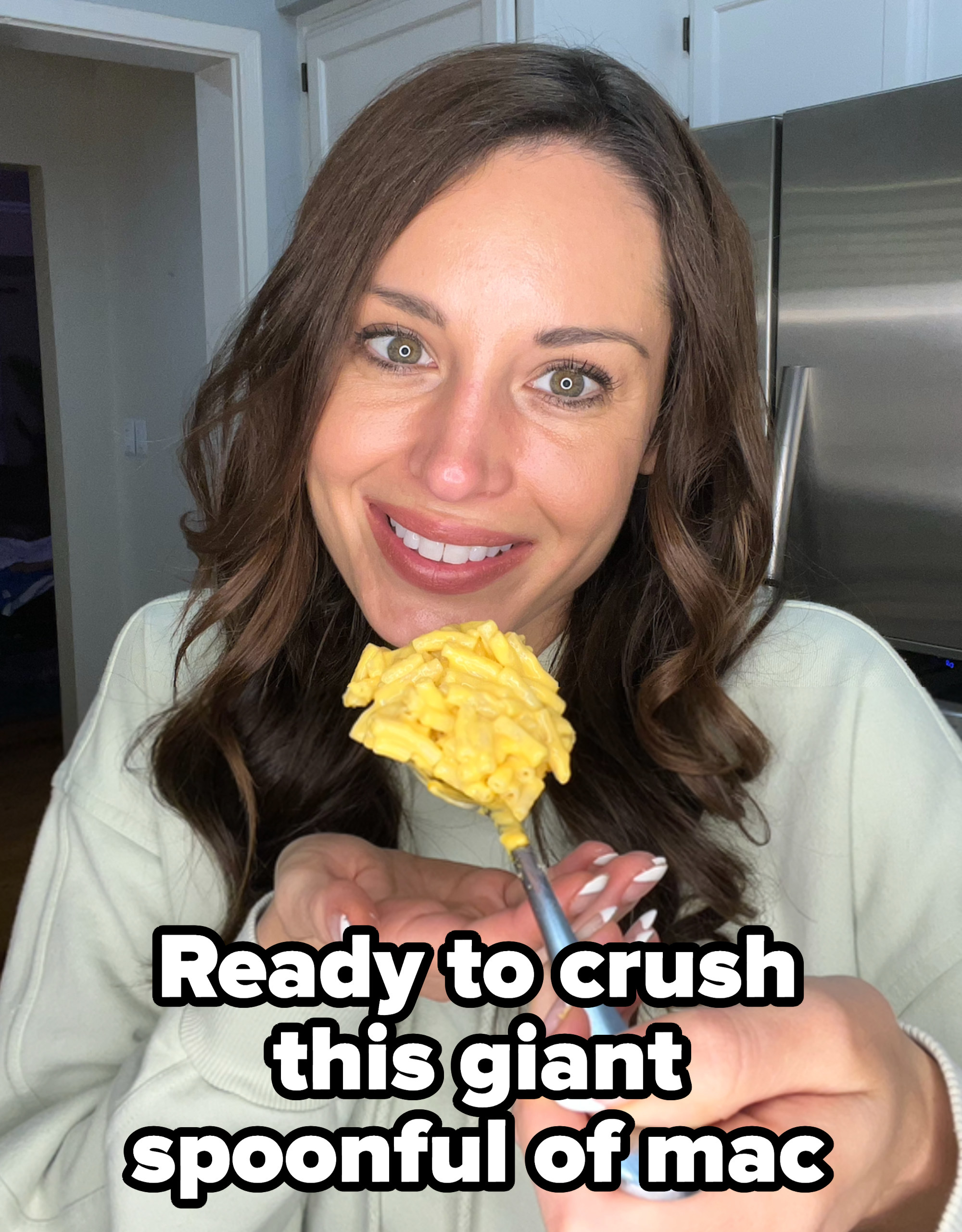 Close-up of the writer smiling and holding a spoon of mac &#x27;n&#x27; cheese with caption, &quot;Ready to crush this giant spoonful of mac&quot;