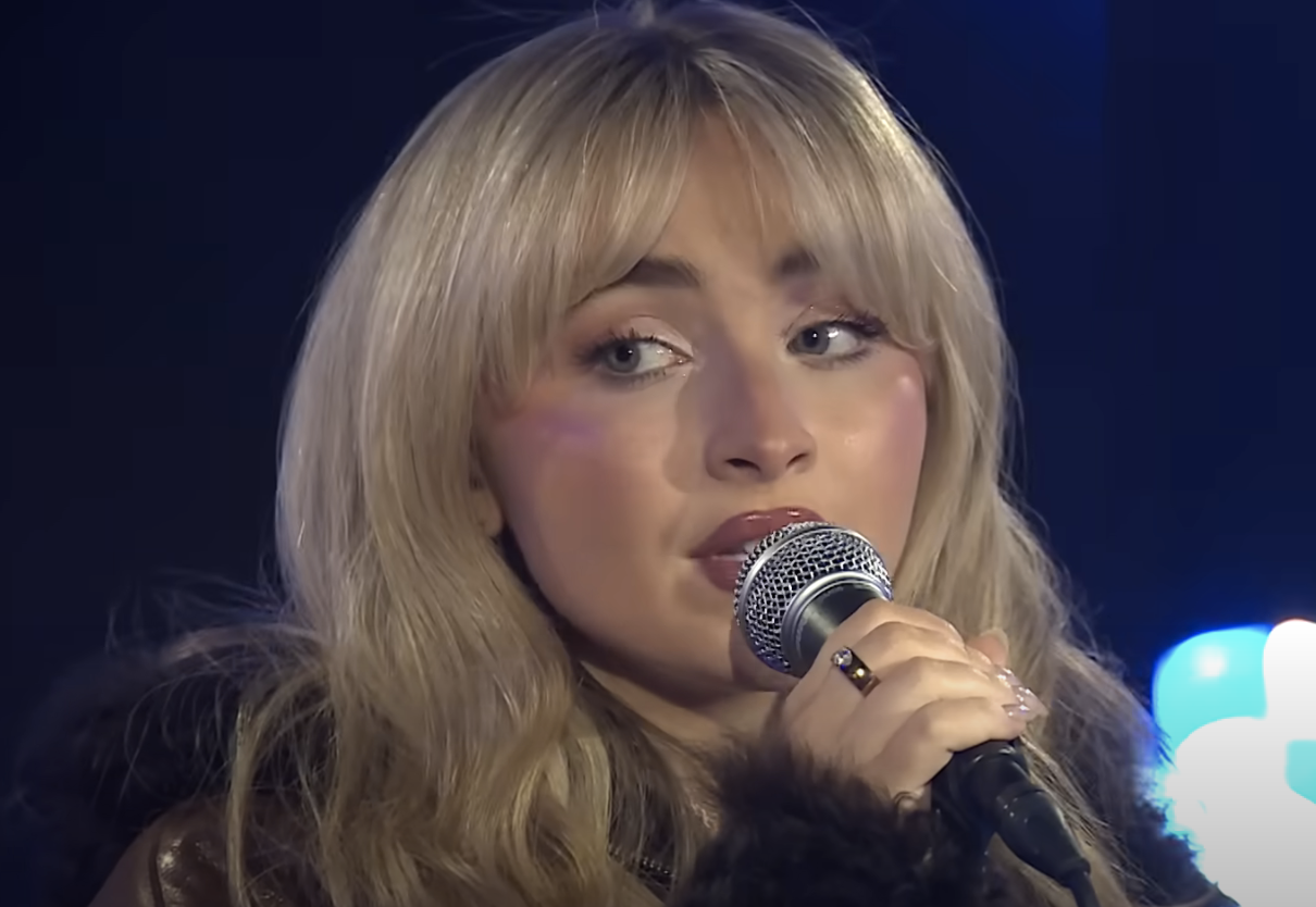 Close-up of Sabrina singing into a microphone