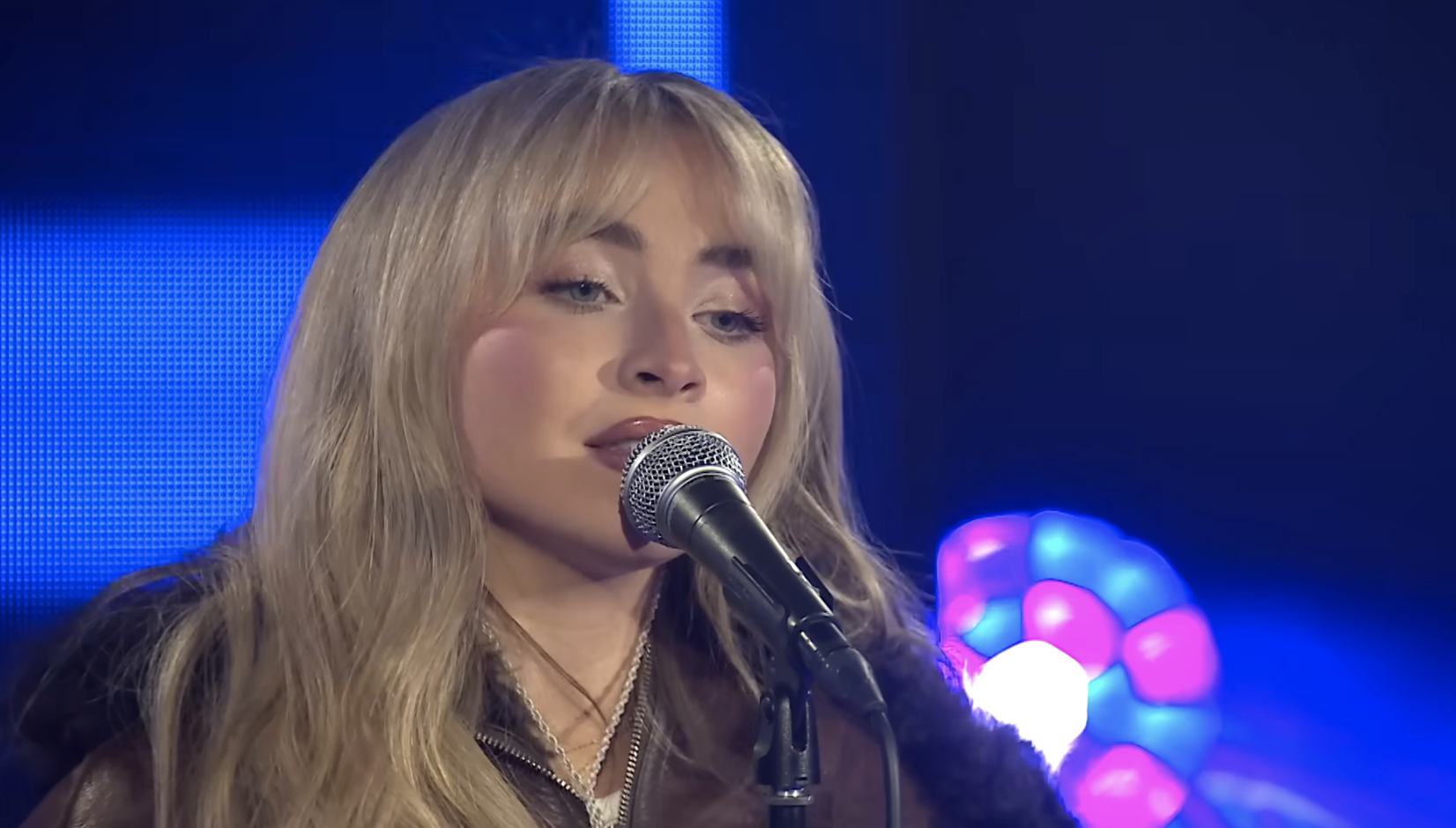 Close-up of Sabrina singing into a microphone