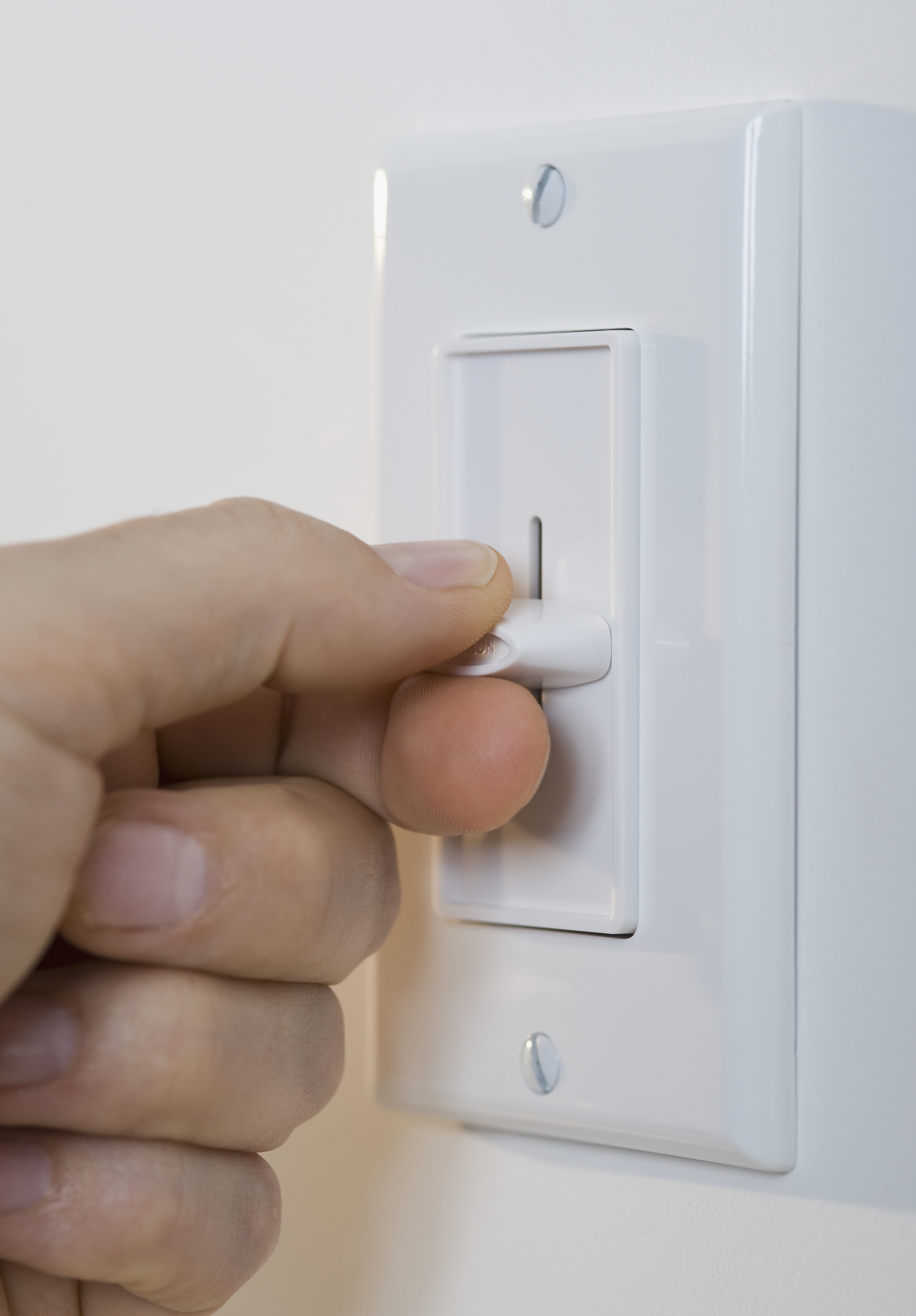 A hand adjusting a dimmer switch