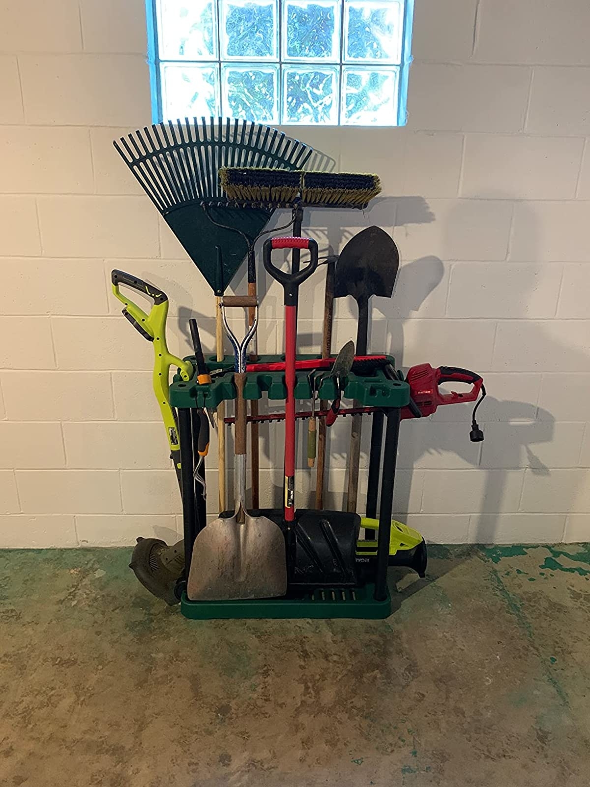 Reviewer&#x27;s rack storing multiple garden tools, like rakes, shovels, brooms, and more