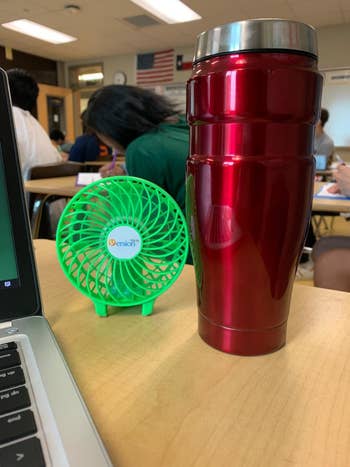 a green fan on a student's desk