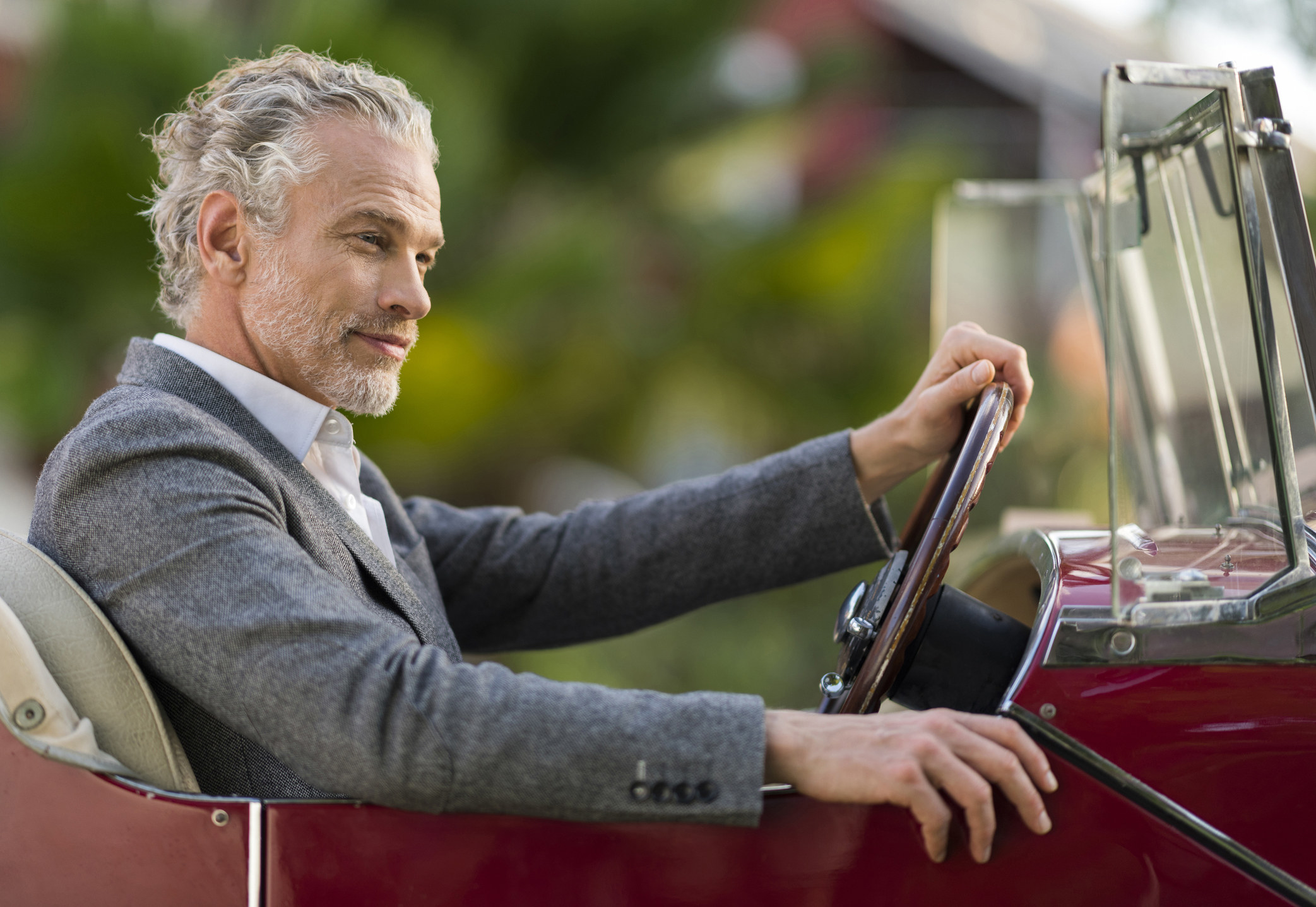 A man driving a convertible car
