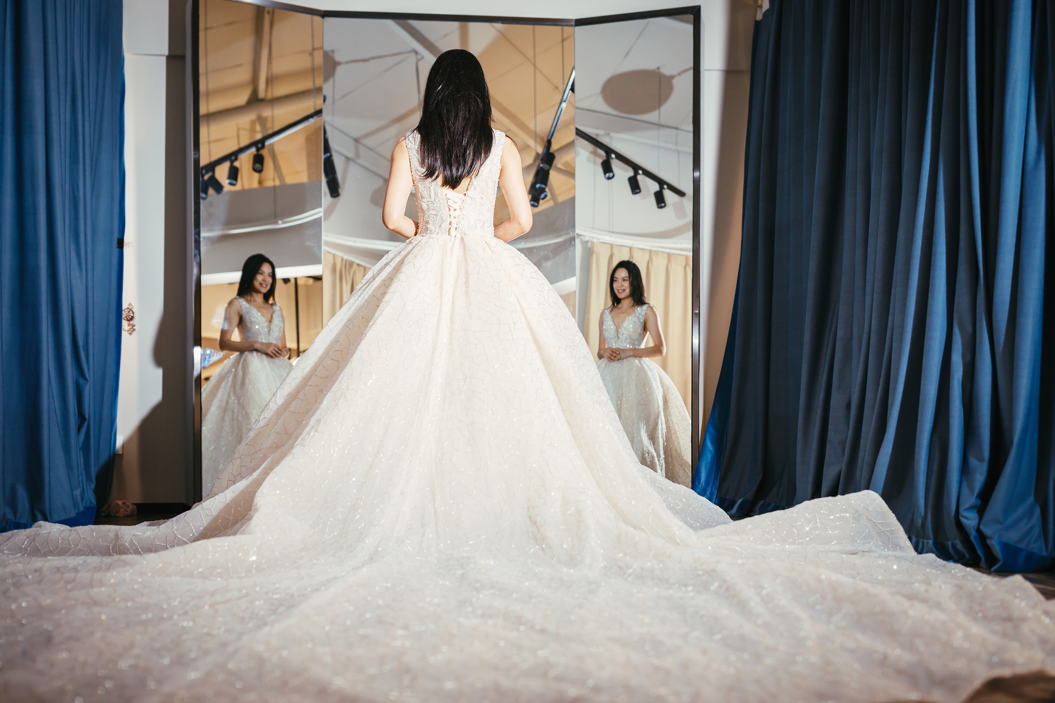 A woman modeling a dress with a huge train