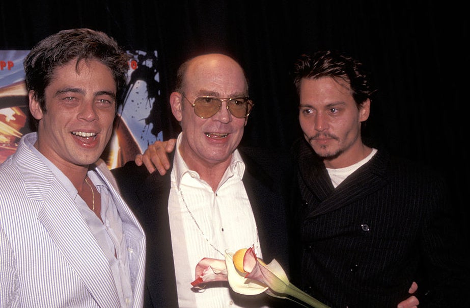 Benicio Del Toro, Hunter S. Thompson and Johnny Depp smiling at a movie premiere