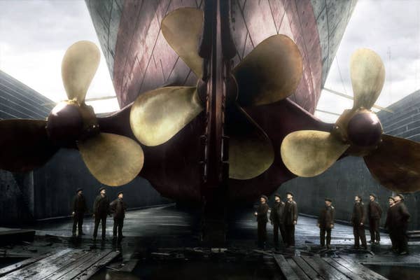 men standing under the huge propellers