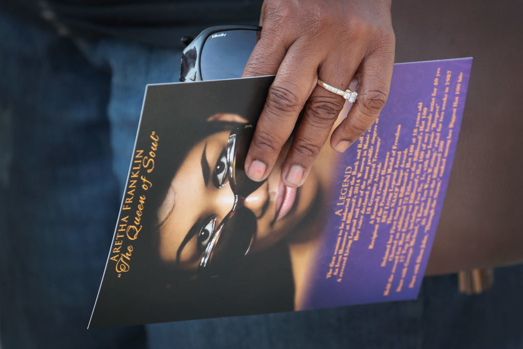 Someone holding a card with Aretha Franklin on it