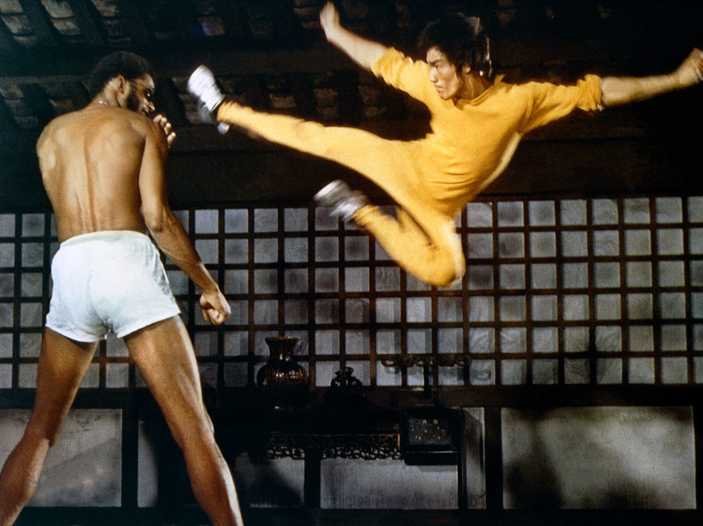 Bruce lee in the air about to kick kareem abdul jabbar, who co stars in the film