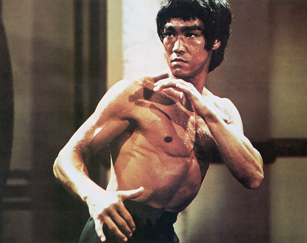 Bruce lee shirtless in a fighting stsance