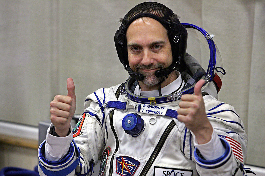 Richard Garriott gestures thumbs up after putting on a space suit
