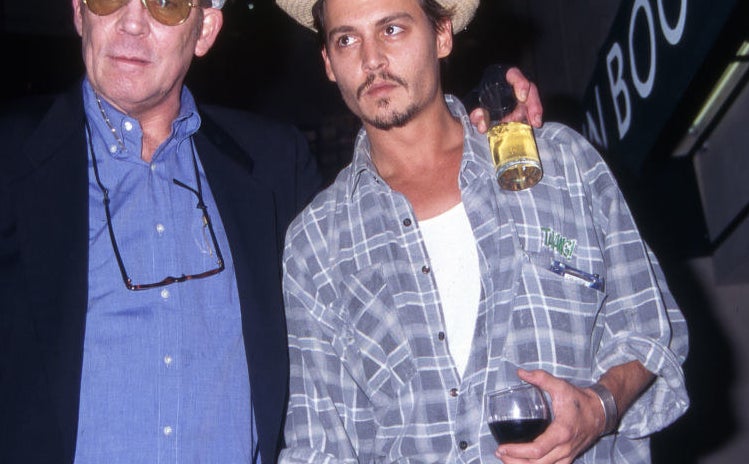 Hunter S. Thompson with his arm around Johnny Depp and a drink in his hand