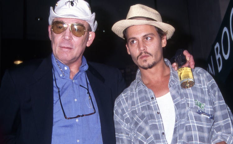 Hunter S. Thompson with his arm around Johnny Depp and a drink in his hand