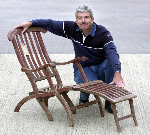 chris posing with a wooden lounge chair