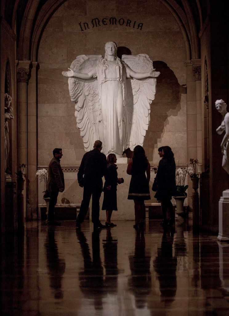 people stand before Elizabeth Taylor&#x27;s burial site at Forest Lawn&#x27;s Great Mausoleum, which has a large angel statue