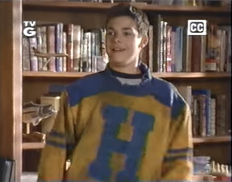 teen wearing an old jersey with a large H on the front