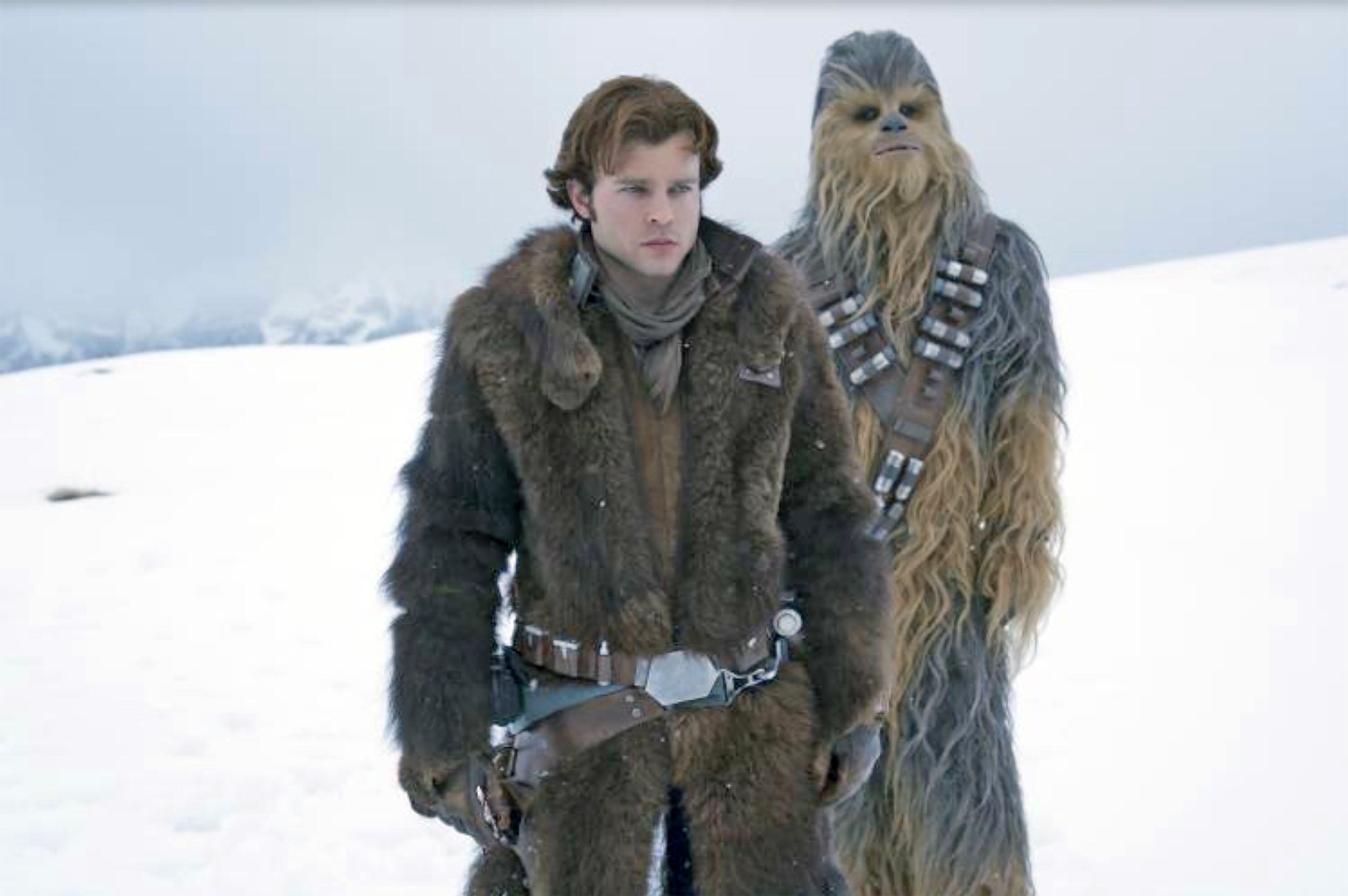 Alden Ehrenreich and Chewbacca stand next to one another on a wintry planet