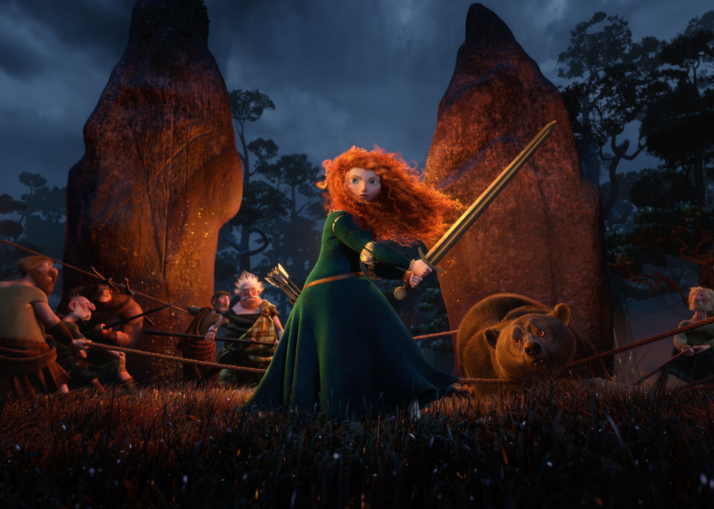 A red-headed woman bears a sword near a bear in a forested area