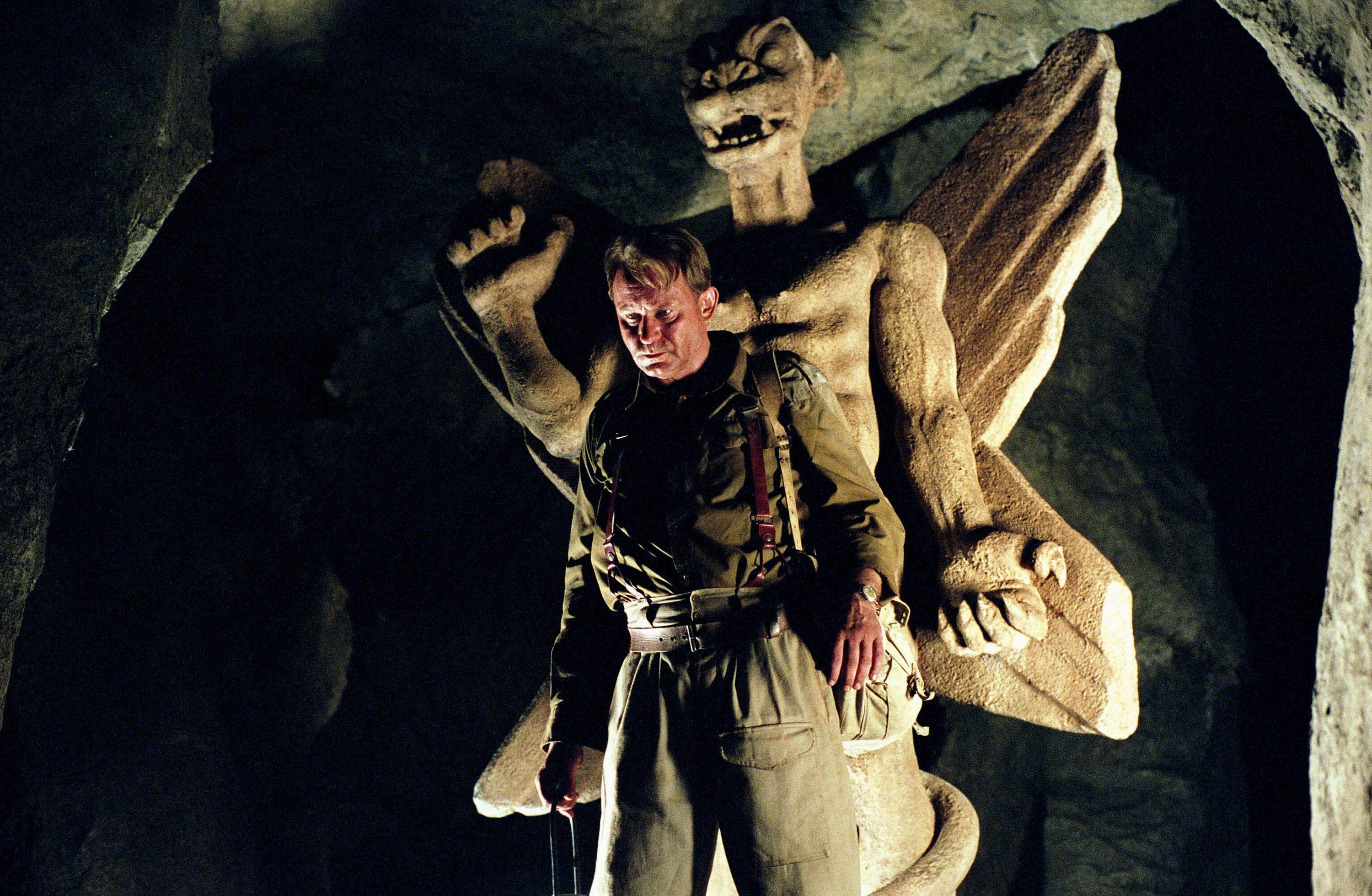 Stellan Skarsgaard stands before a large terrifying demon statue