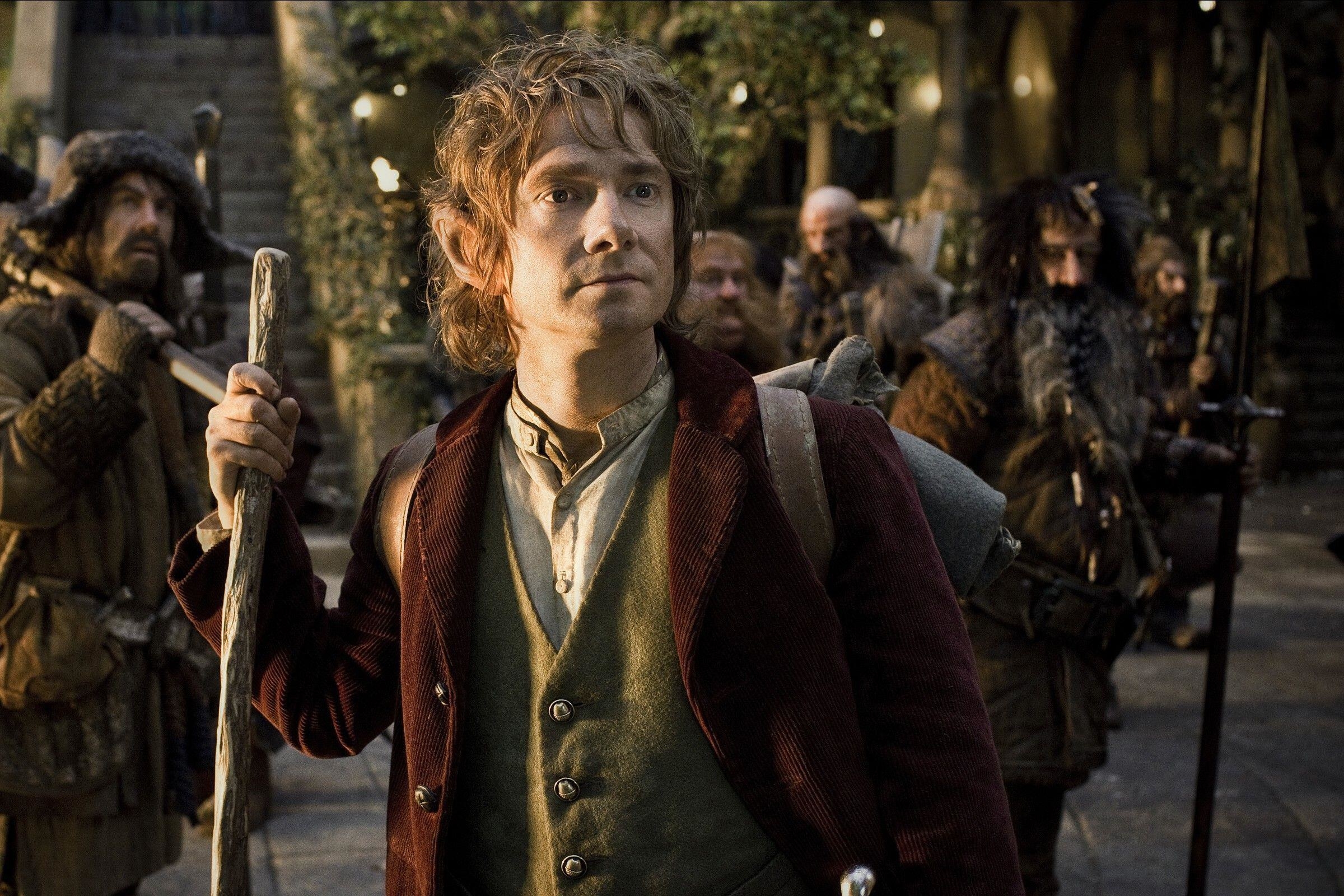 Martin Freeman as Bilbo Baggins holds a walking stick and backpack in the first &quot;Hobbit&quot; film