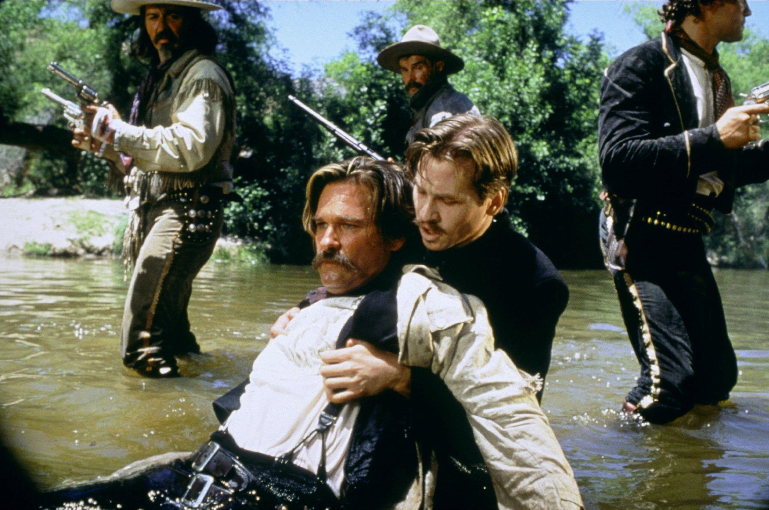 Val Kilmer holds Kurt Russell after the latter fell in a river