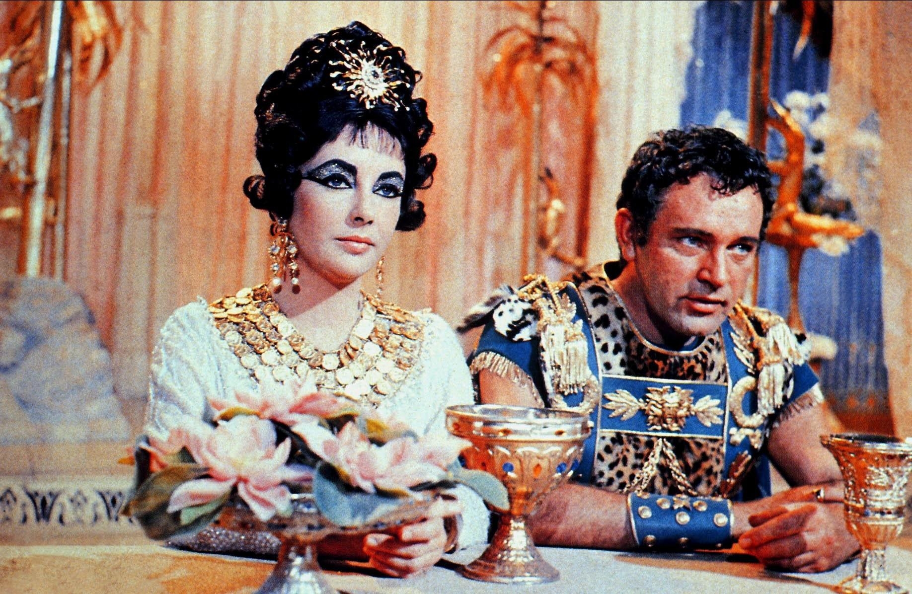Richard Burton and Elizabeth Taylor sit on set of “Cleopatra”