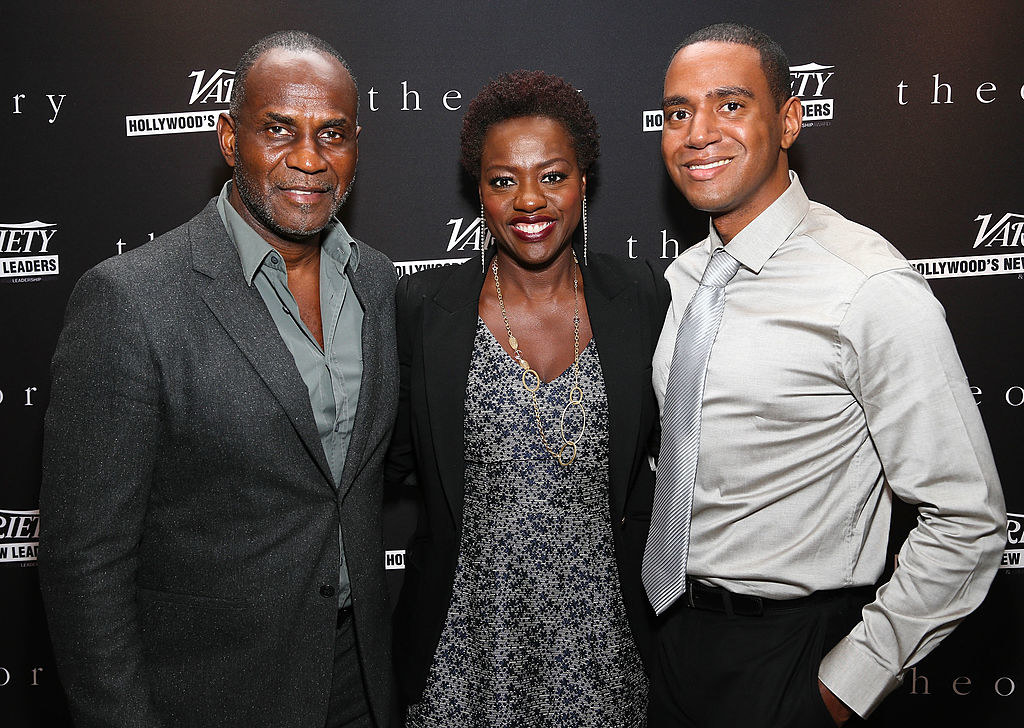 Viola smiling with Kaylon and Julius at a media event