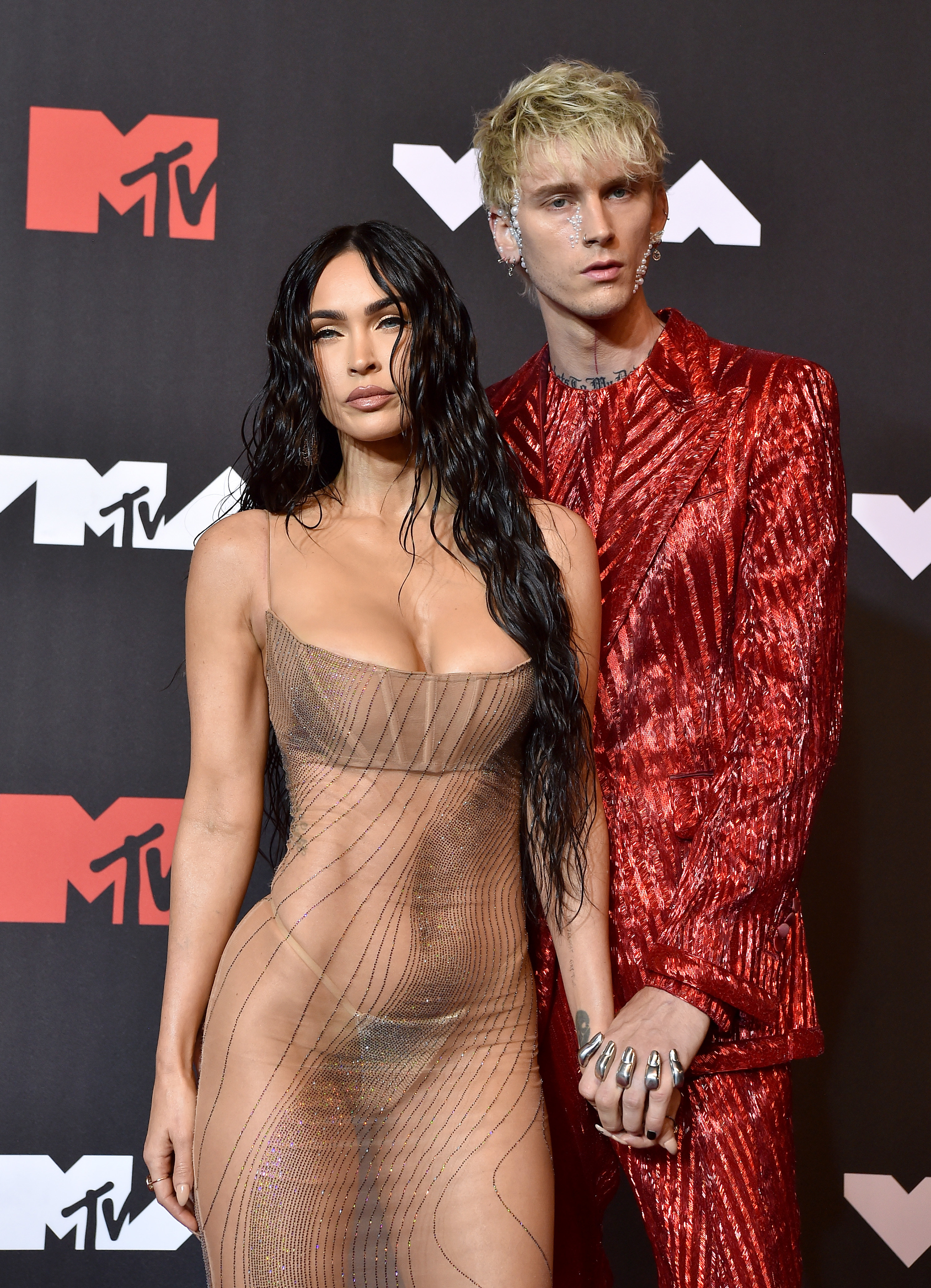 Megan in a sheer outfit and MGK in a sparkly suit at an MTV event