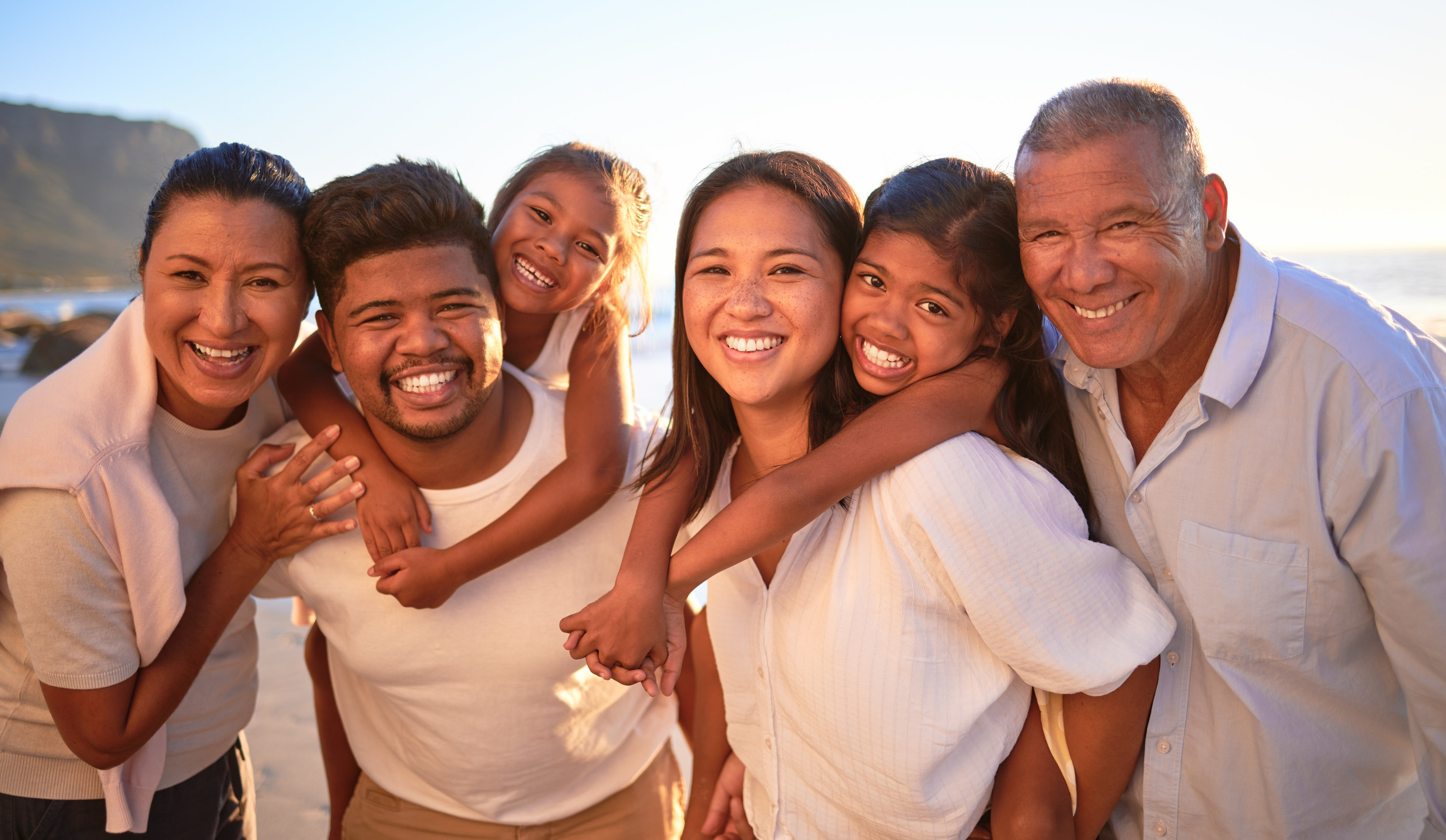 A multicultural family smiling and all wearing white