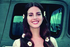 Lana Del Rey smiling with daisies in her hair on the Lust for Life album cover
