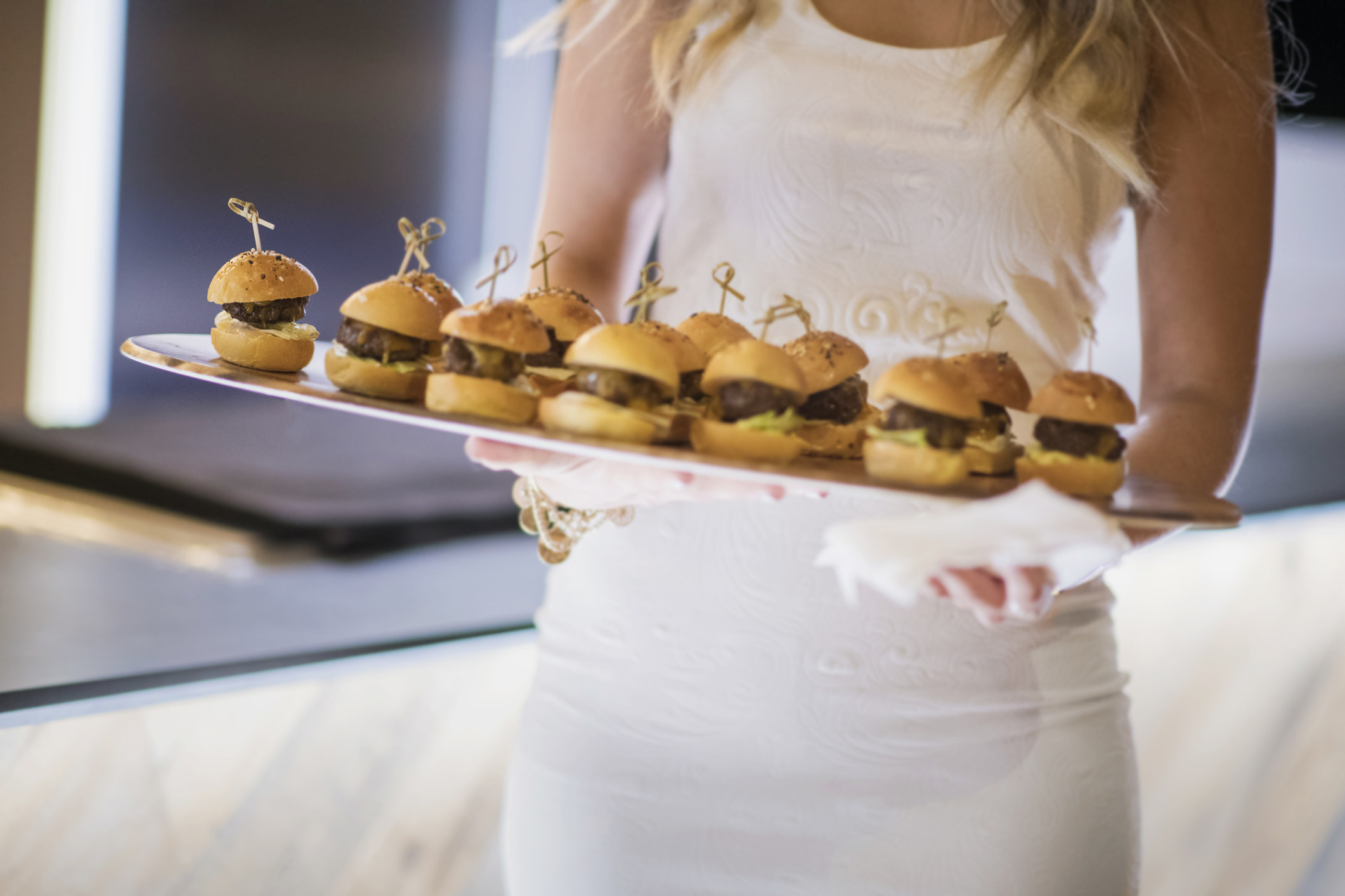 woman holding a plate of sliders