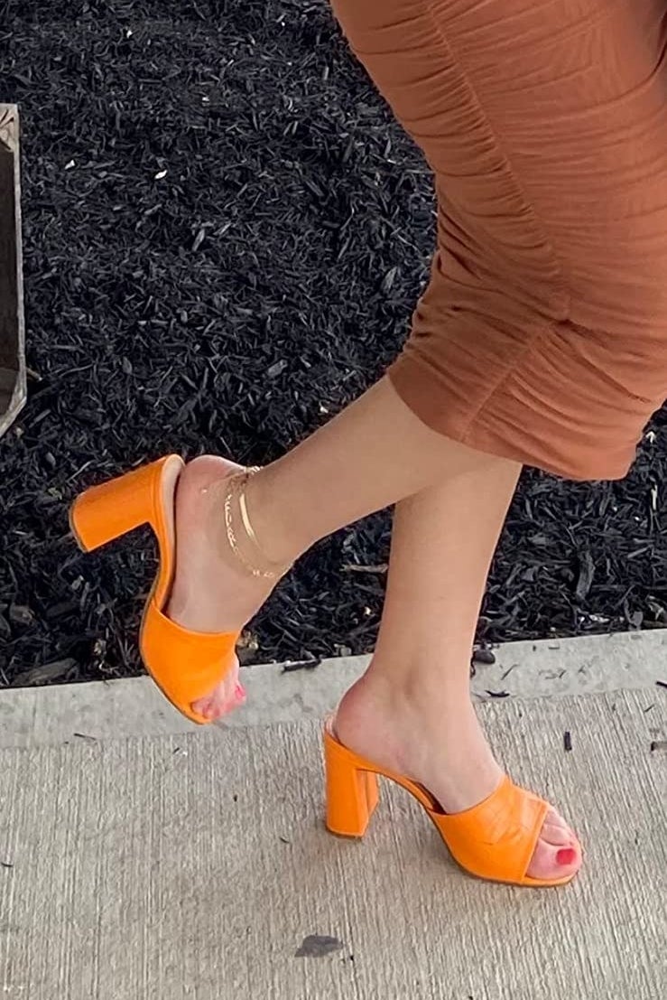 A reviewer wearing orange sandals