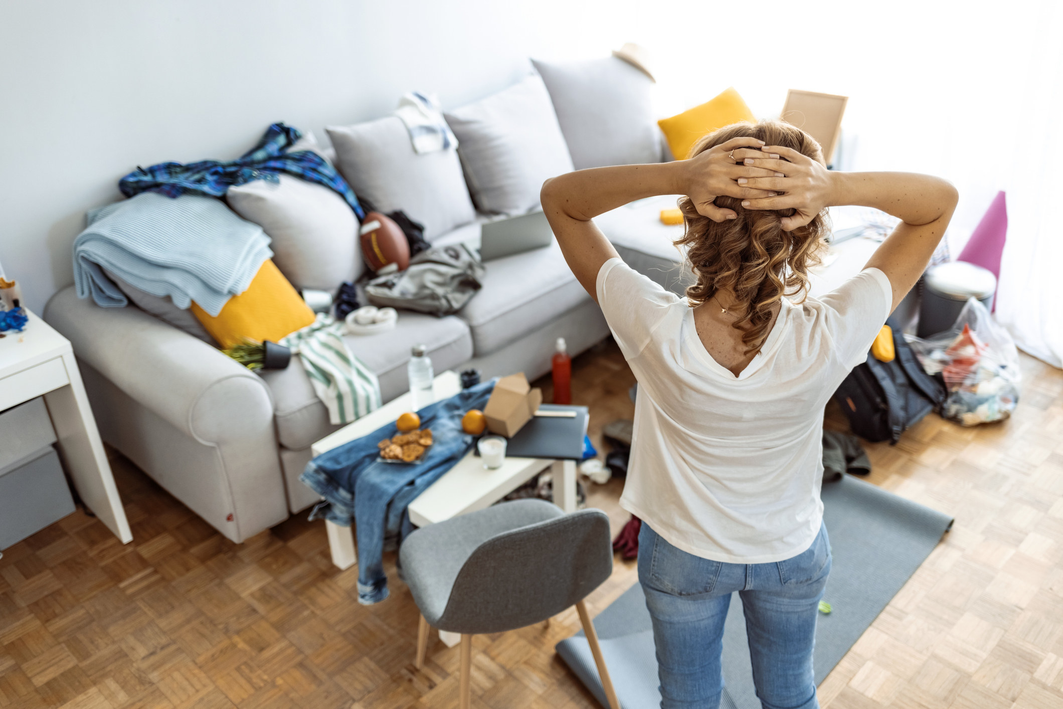 a woman is stressed because the living room is so messy