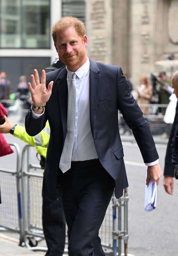 Prince Harry waves as he enters an agreement