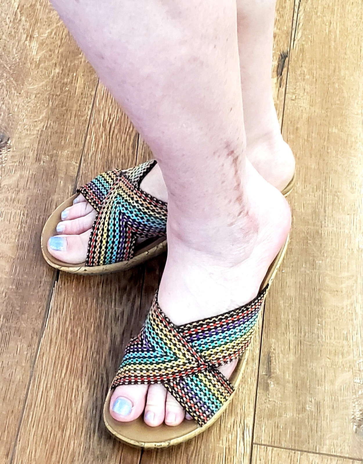 A reviewer wearing rainbow shoes