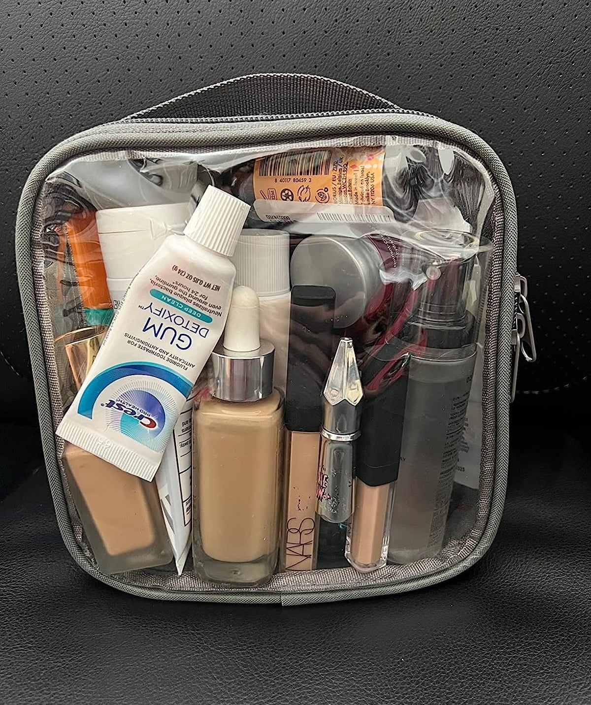 reviewer&#x27;s grey-trimmed see-through bag full of cosmetics