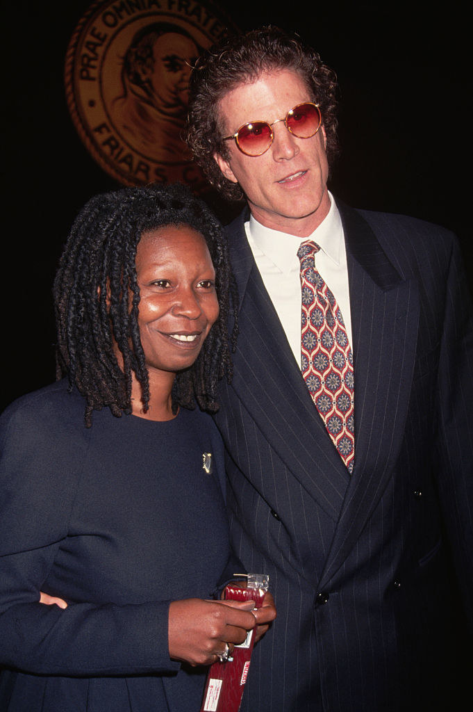 Whoopi smiling next to Ted, in a suit and tie