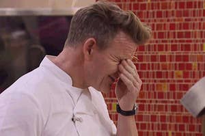 Gordon Ramsay with his hand to his forehead as if stressed.